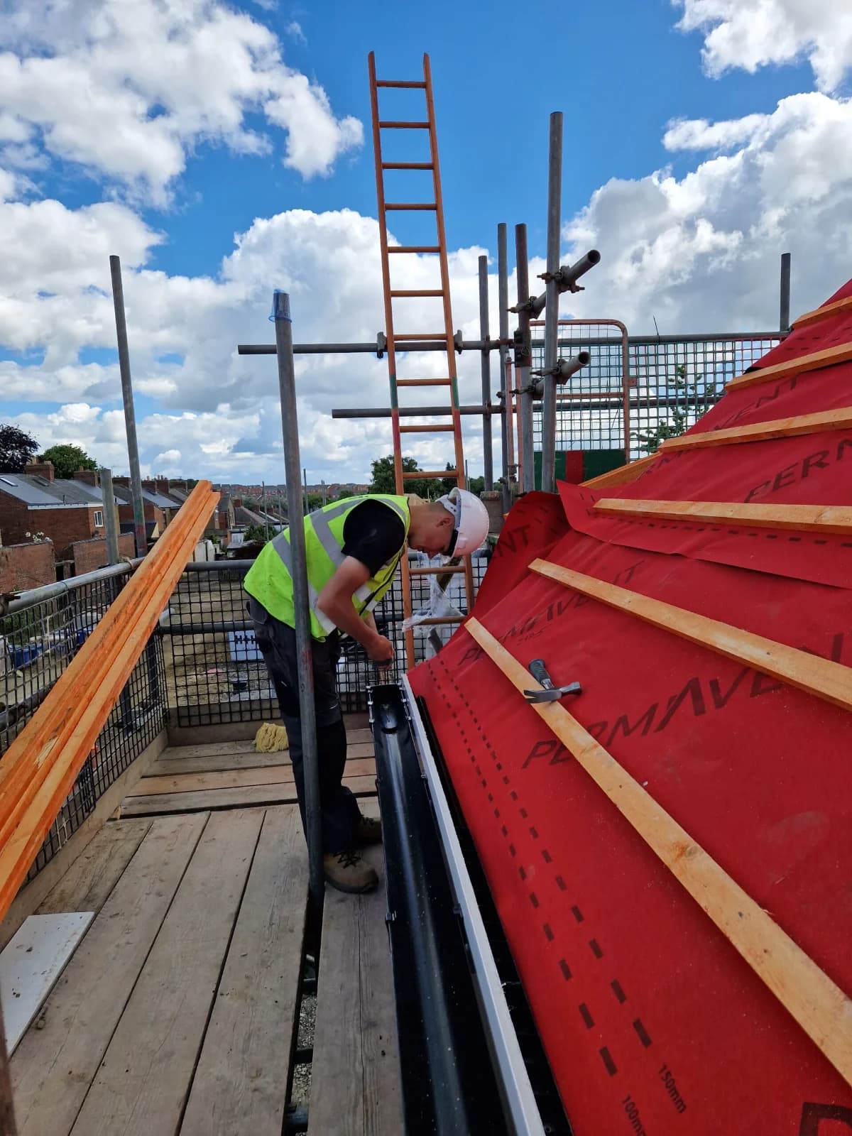Roofer working on a roof in breather membrane and battens during a repair in County Durham